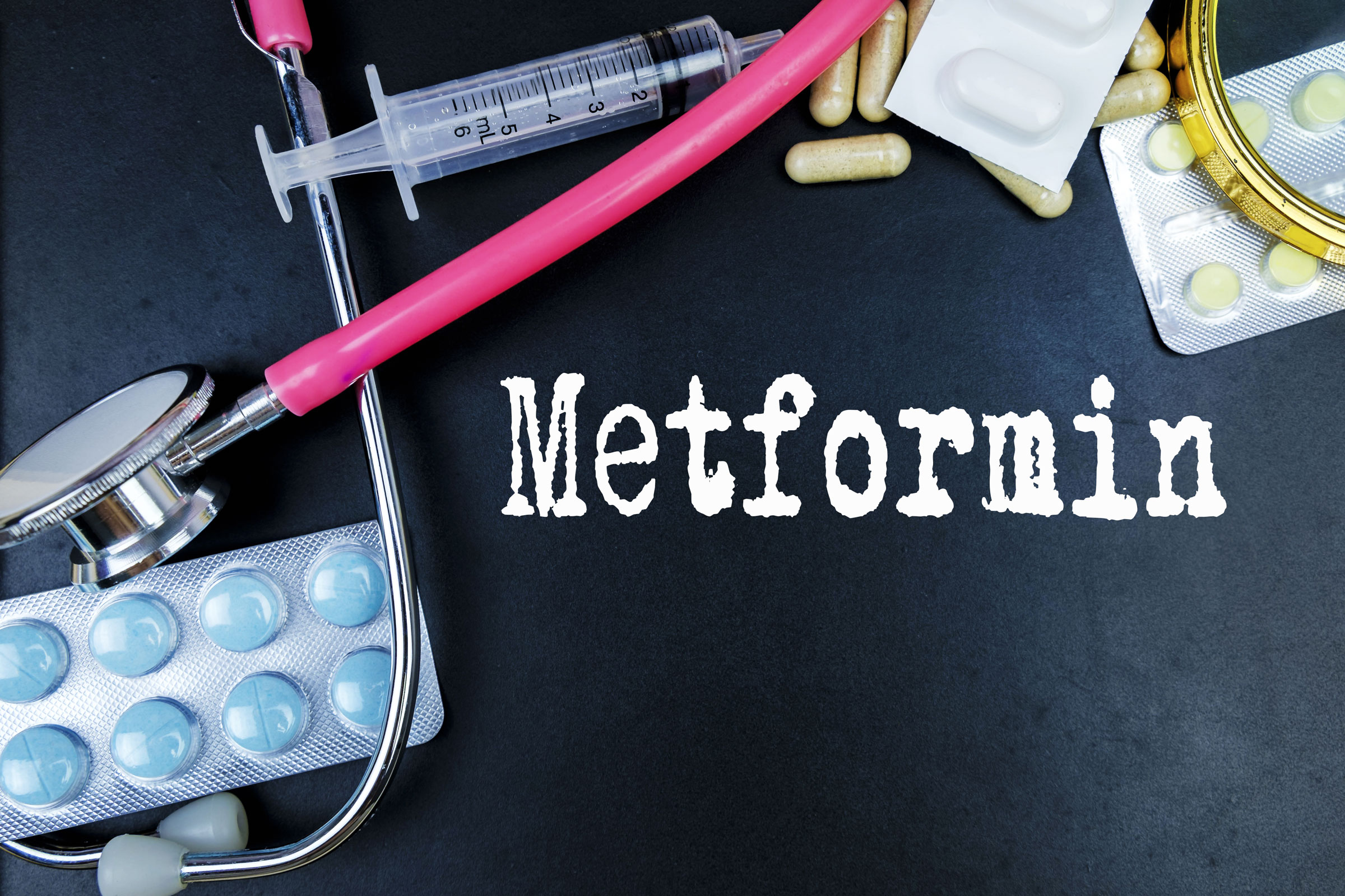 Metformin tablets alongside clinical research materials, representing the study of Metformin in healthy aging